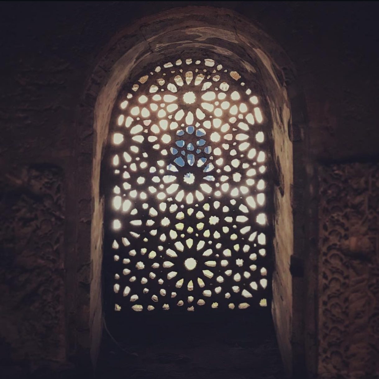 Una celosía de la Alhambra desde la penumbra